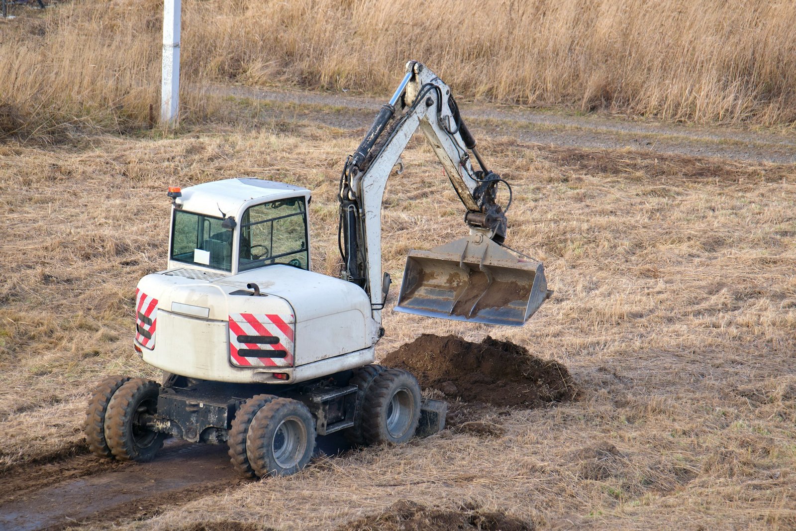 Earth moving tractor preparing place for future house foundation construction. Leveling soil for